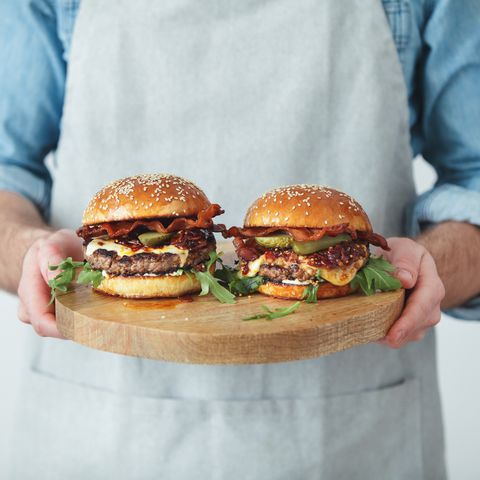 Man holding homemade angus beef burgers with bacon whisky jam