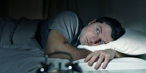 man in bed eyes opened suffering insomnia and sleep disorder