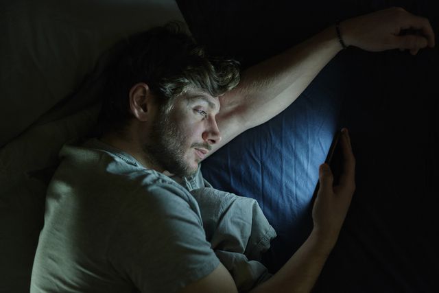 man in bed on smartphone