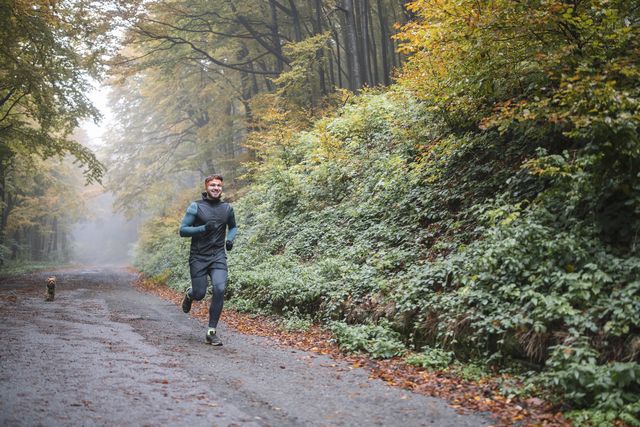 man jogging with his dog in autumn