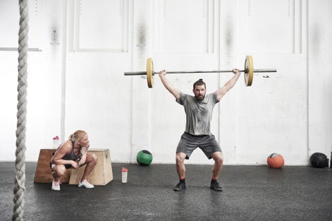 Man lifting barbell in cross training gym Man lifting barbell in cross training gym