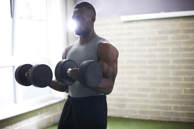 man lifting dumbbells in gym