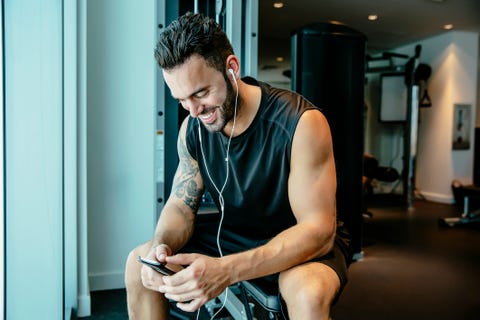 uomo che ascolta gli auricolari in palestra