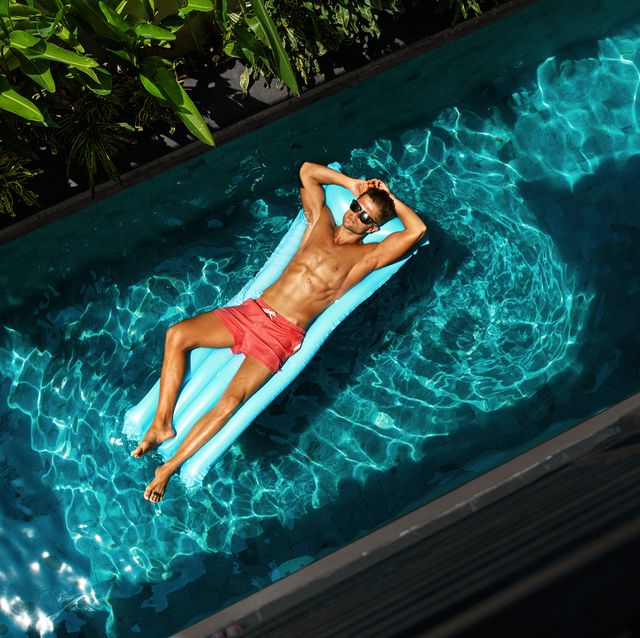 Man On Summer Vacation. Male Model Tanning In Swimming Pool