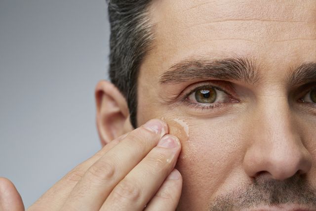 man putting anti wrinkle gel around the eyes