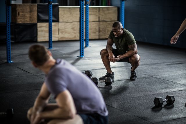 man resting in between sets at cross training gym
