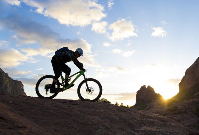 a man rides his enduro style mountain bike at sunset in sedona, arizona, usa