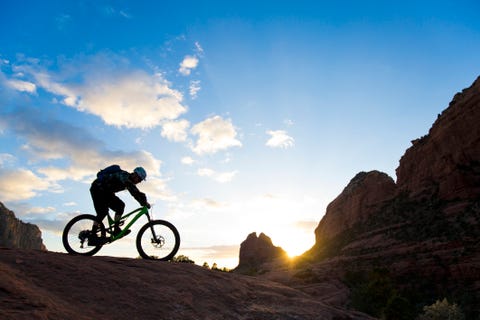 a man rides his enduro style mountain bike at sunset in sedona, arizona, usa