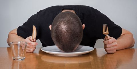 Man sleeping on a plate, tired of waiting for food.