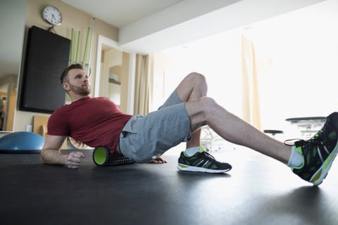 Man stretching back on roller in physiology clinic gym