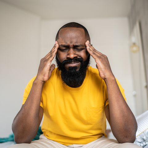 man waking up with headache at home