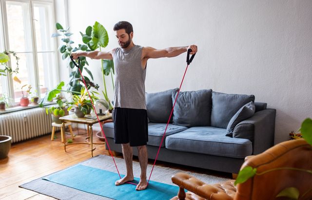 man watching online videos and doing exercise at home