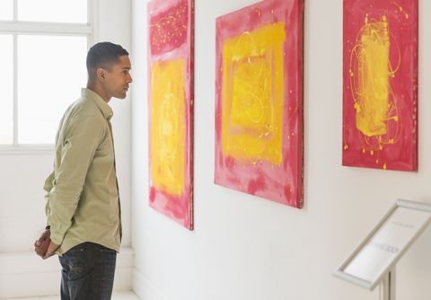 man watching paintings in modern art gallery