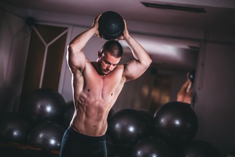 Man working out with ball in gym