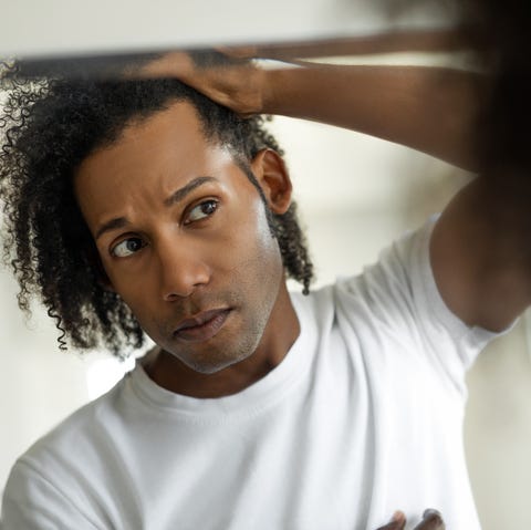 man worried for alopecia checking hair for loss