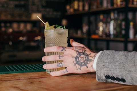 Mans hand reaching for a cocktail in a bar mans hand reaching for a cocktail in a bar