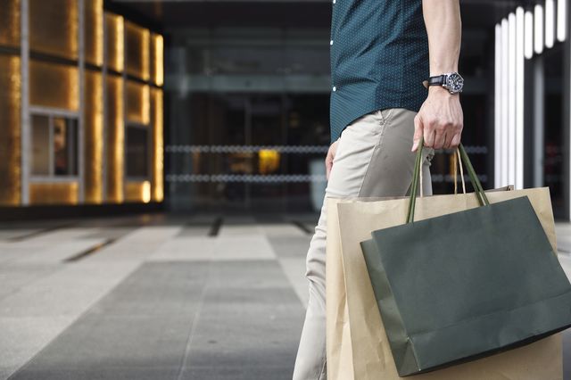 man's legs and shopping bags outside a luxury mall