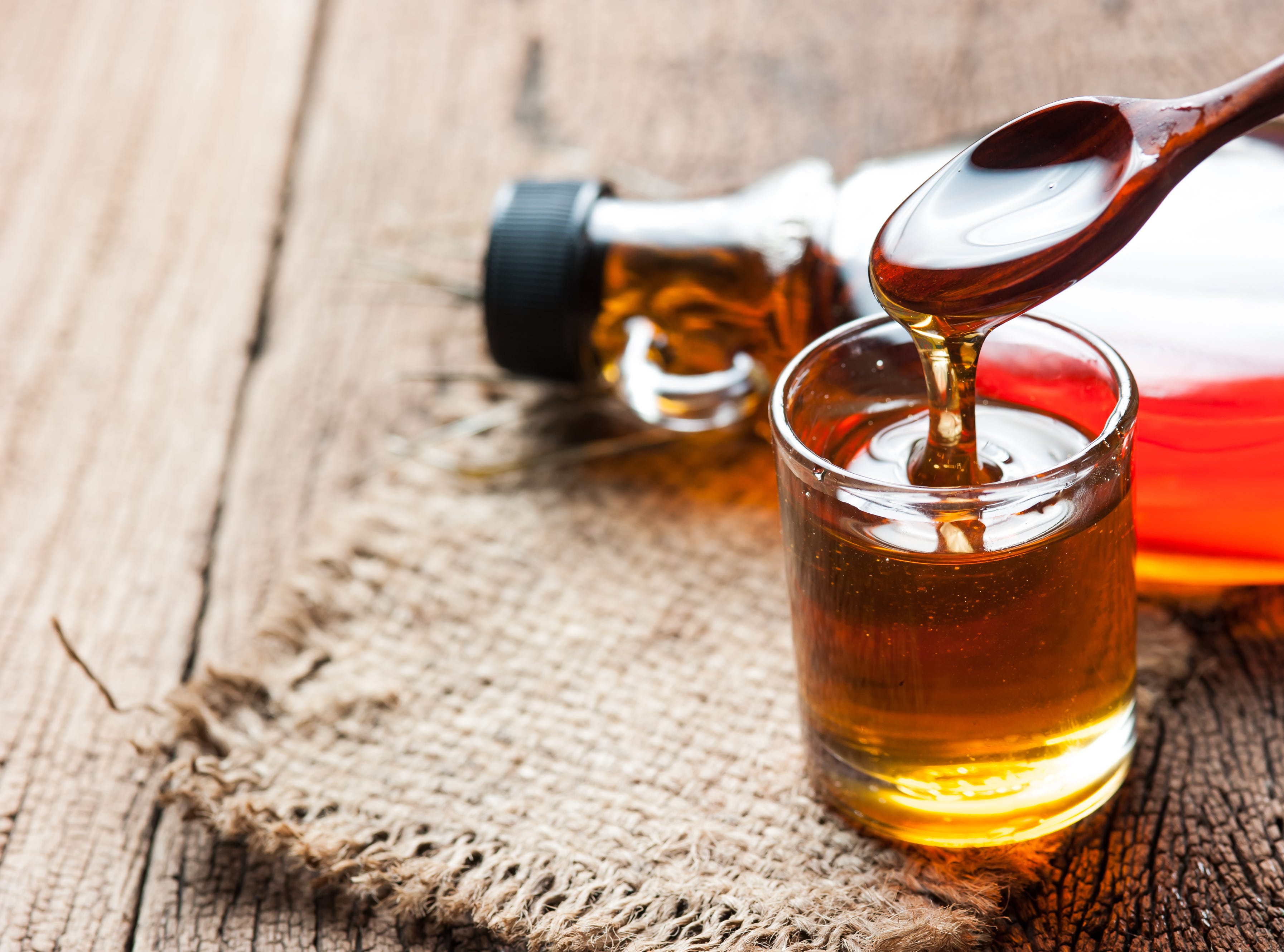 Sirop d'érable en bouteille de verre sur table en bois