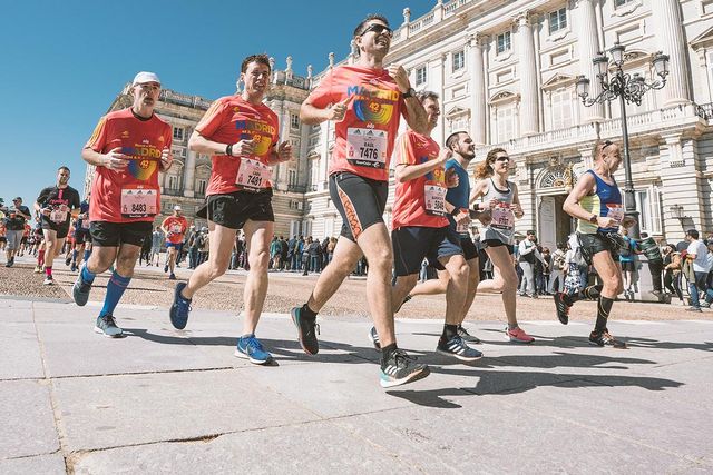 varios corredores corriendo por delante del palacio real en madrid