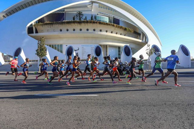 varios corredores de élite pasan por delante de un edificio de la ciudad de las artes y las ciencias durante el maratón de valencia 2021