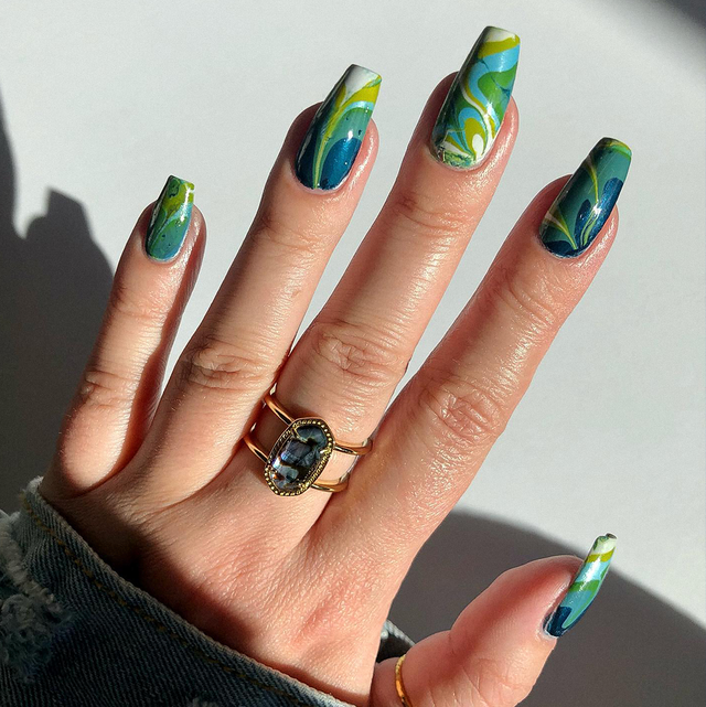 two hands with marble nail designs