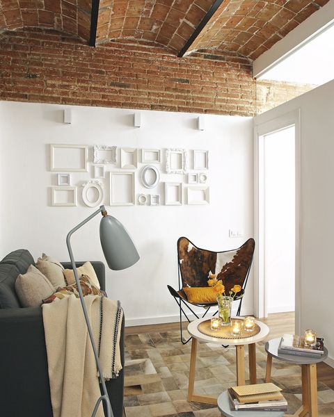 salón con bovedillas en ladirllo visto y decoración de pared con marcos de distintas formas
