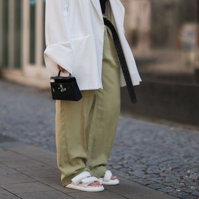 a model wears cloud slides in her street style to illustrate a shopping guide to the best cloud slides 2022