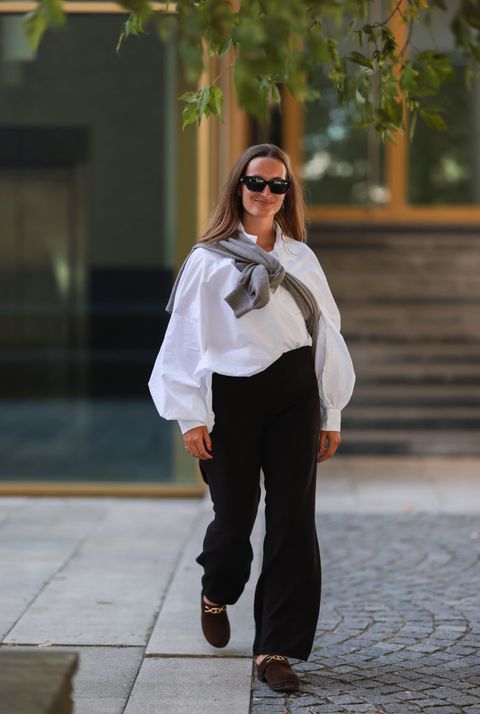 street stylepersoon met zwarte broek witte blouse en trui