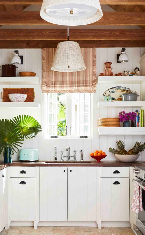 mahogany countertops, abaco pine beams, and vintage wicker pendant shades ground the kitchen in organic island simplicity