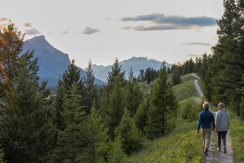 mature couple walk down trail at sunrise