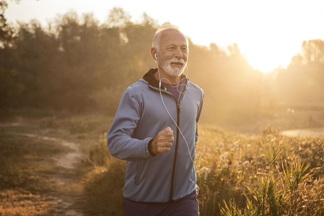 mature man jogging in by lake in morning time ,feeling young again