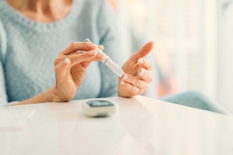 Mature Woman Doing Blood Sugar Test at home.