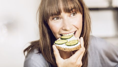 mature woman eating healthy cucumber bread