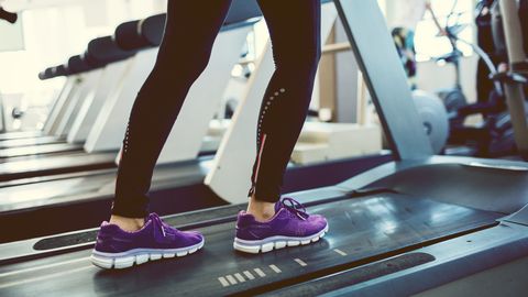 Mature Woman Exercising In Gym On Treadmill.
