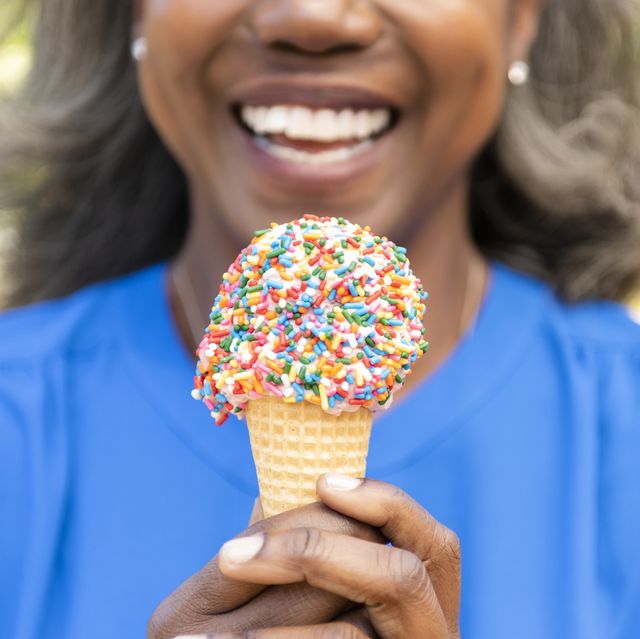 mature woman holding ice cream cone with sprinkles
