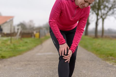 Mature Woman Holding Knee On Road