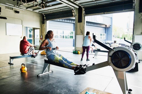 african american on rowing machine during workout in gym