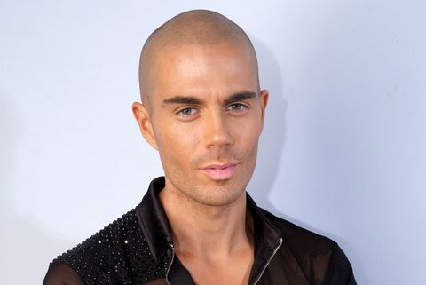 max george wearing a black sequin top posing with arms crossed for a dance tour photo call.