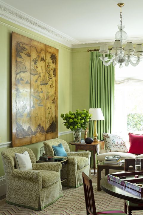 a pair of syrie maugham chairs in the sitting room are covered in a panther print velvet and a 1950s chinoiserie panel hangs above