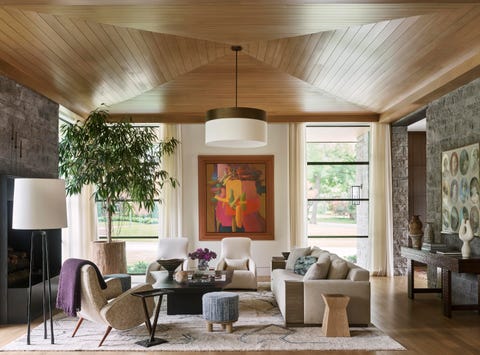 a sofa and chairs in a large living room with a paneled wood ceiling