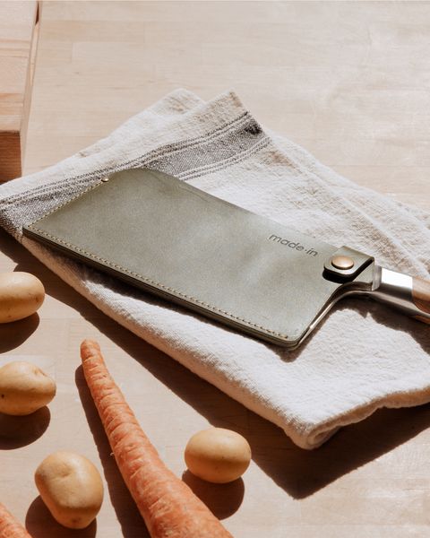 a cleaver on a cloth napkin with potatoes and carrots