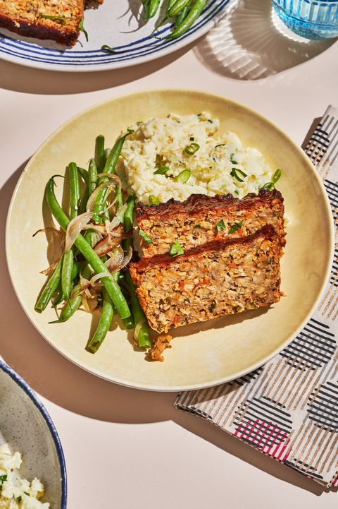 vegan meatloaf on a tan plate with green beans and mashed potatoes