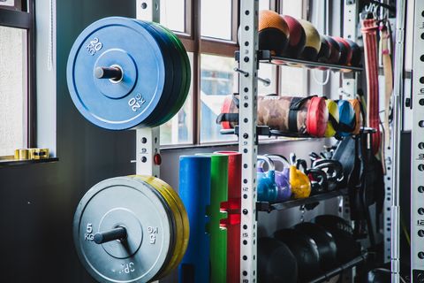 medicine balls, kettlebells and variety of weight training equipments on a rack