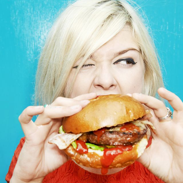 mujer comiendo una hamburguesa