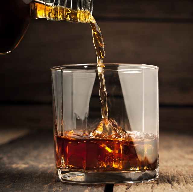 una botella de whisky sirviendo en un vaso