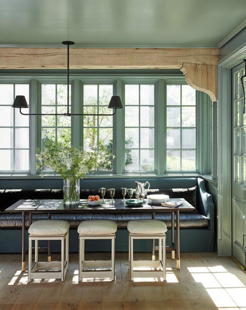 the breakfast room is painted high gloss castle gray by farrow and ball and the ivory leather stools are custom theres a built in leather banquette