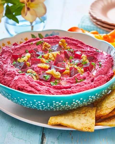 beet hummus with walnuts on top and pita chips