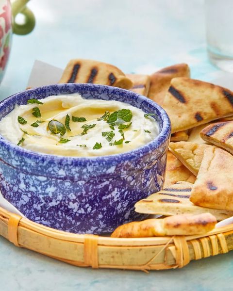 whipped feta dip in blue bowl with pita wedges