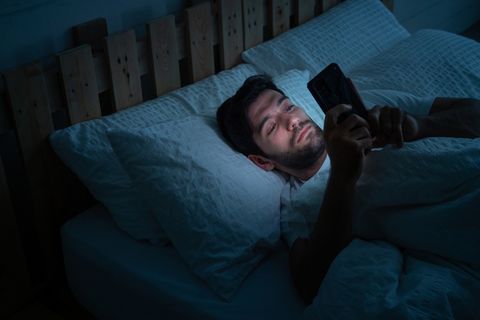 erkekler yatakta uzanıp sürekli telefonla oynuyor sosyal medya bağımlısı, dinlenmek için zaman yok
