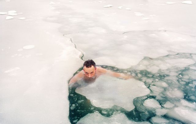 men swimming in frozen sea